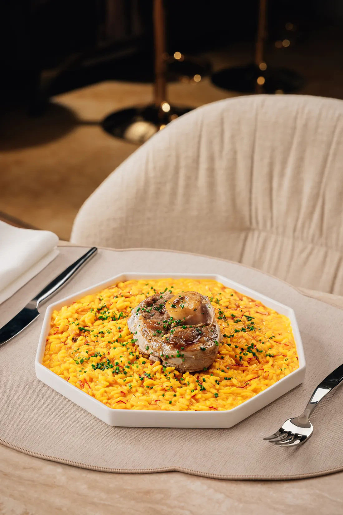 Saffron risotto with ossobuco and chives on an octagonal plate