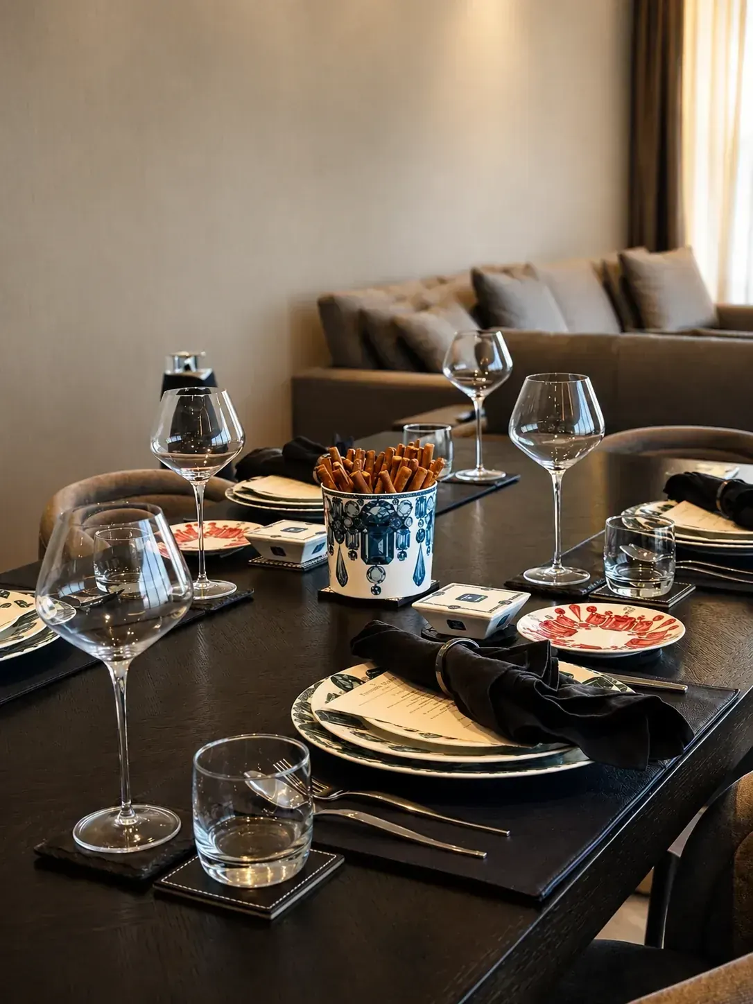A private dining table dressed with printed menus, crystal glassware and hand-painted plates